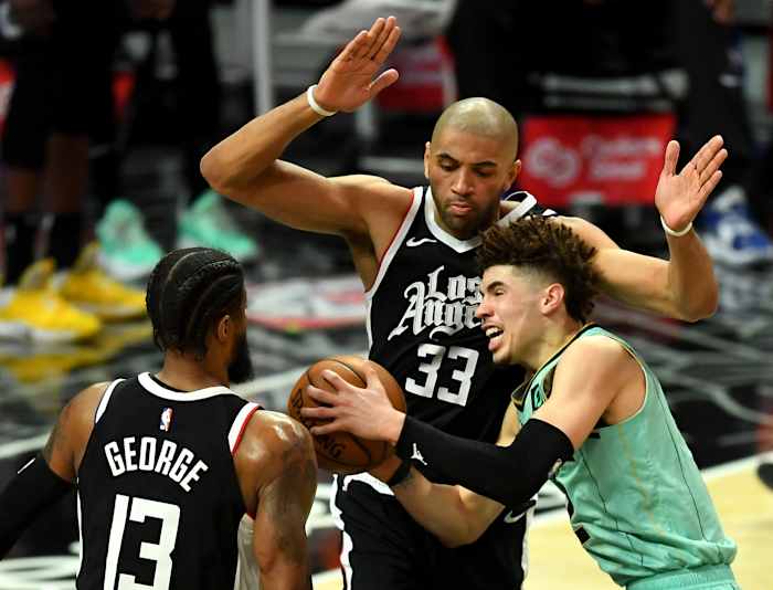 Mar 20, 2021; Los Angeles, California, USA; Charlotte Hornets guard LaMelo Ball (2) is fouled by Los Angeles Clippers guard Paul George (13) as Los Angeles Clippers forward Nicolas Batum (33) defends under the basket in the second half of the game at Staples Center. Mandatory Credit: Jayne Kamin-Oncea-USA TODAY Sports